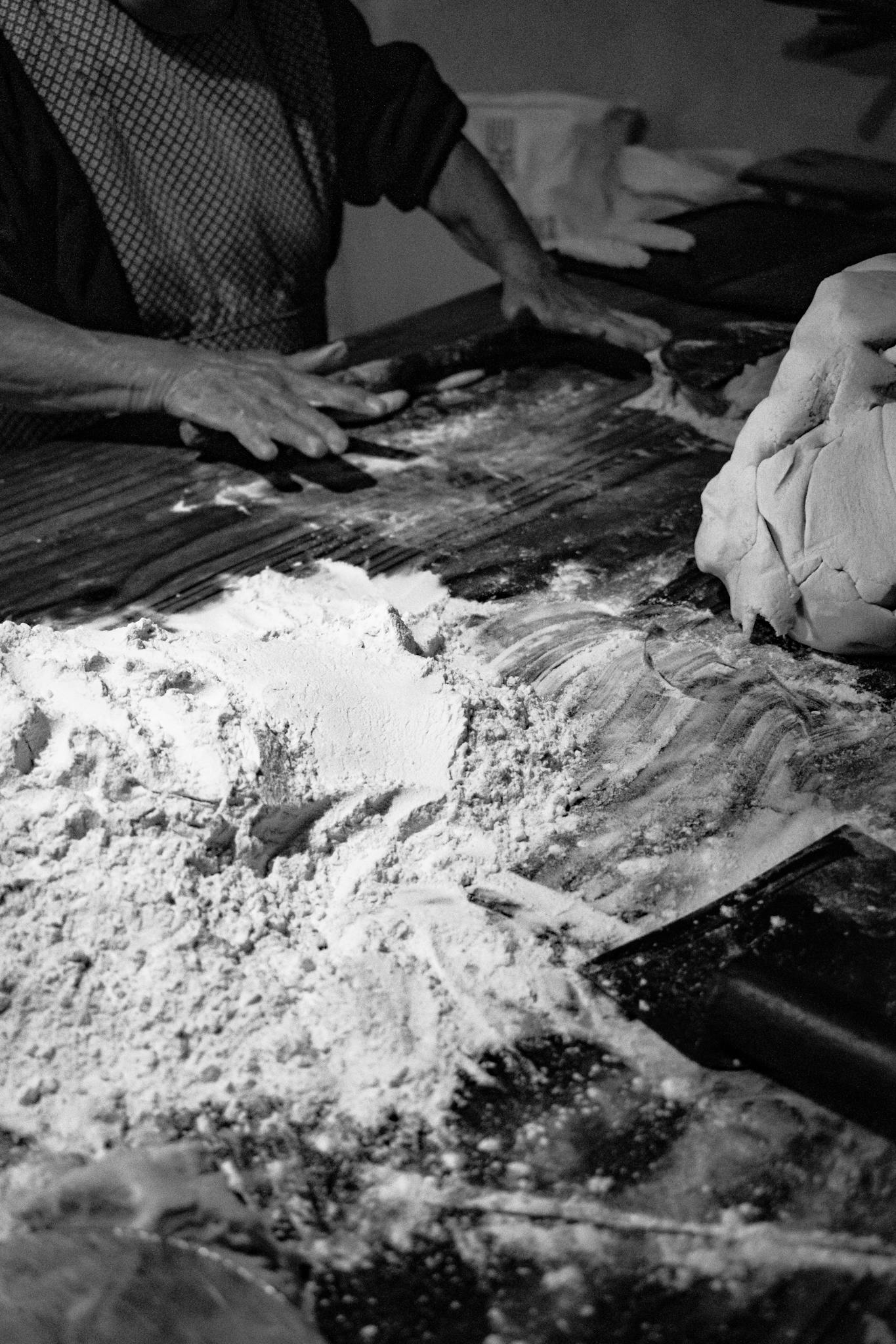 Hands work dough in a Mexican bakery with flour scattered on the table. Authentic craftsmanship in Pahuatlán.